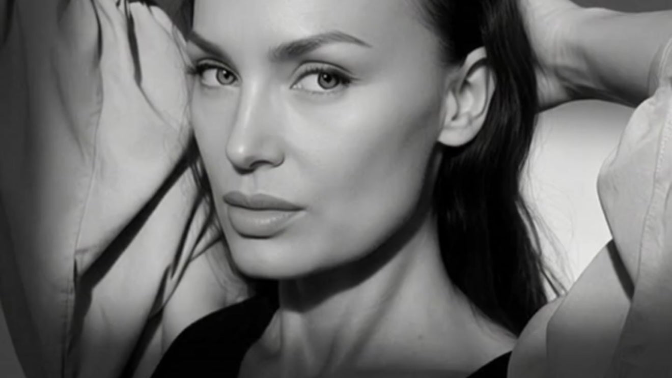 Black and white portrait of a woman with her hands behind her head